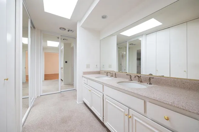 a spacious bathroom with a granite countertop sink mirror and