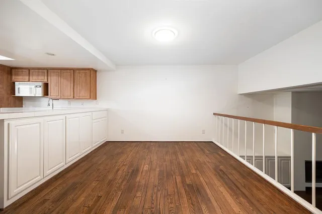 a view of a kitchen with wooden floor and electronic appliances