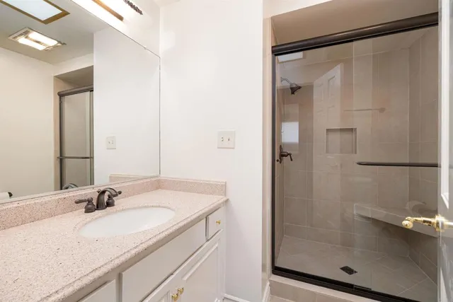 a bathroom with a granite countertop sink mirror and shower