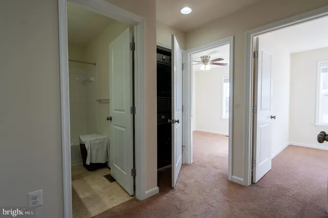 a bathroom with a granite countertop sink and a bathtub next to a window