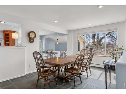 a view of a dining room and livingroom with furniture wooden floor and a clock