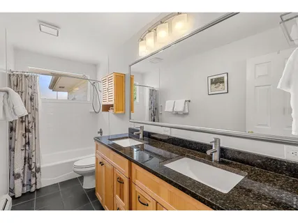 a bathroom with a sink a toilet a mirror and shower