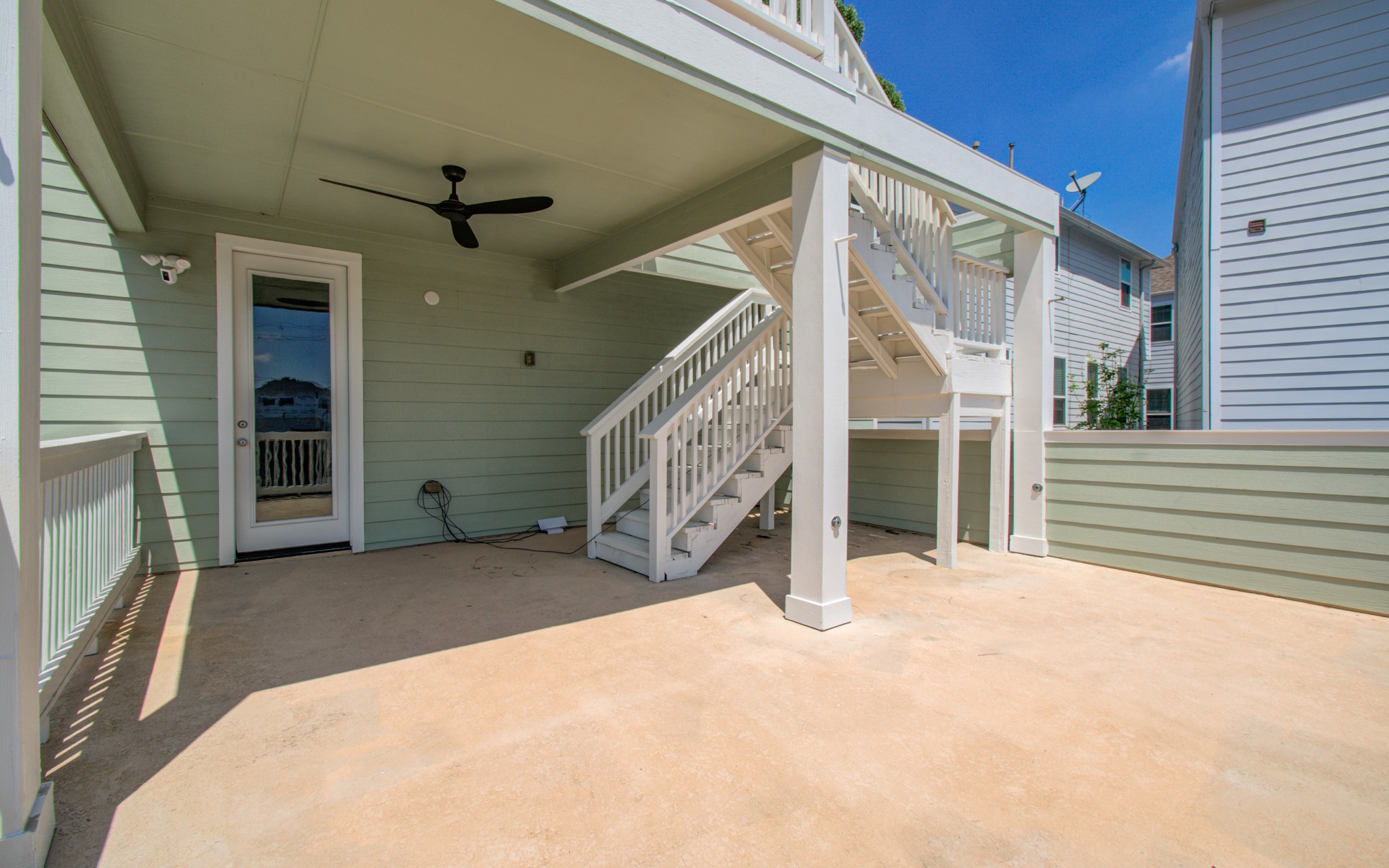 6621 North Main Street Houston, TX 77009 - Photo 21 of 41 This spacious outdoor patio area with a ceiling fan, covered deck, and exterior stairs leading to an upper level. The light green siding and white trim add a fresh look, while the space offers potential for outdoor entertaining or relaxation.