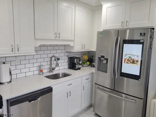 a kitchen with a refrigerator sink and cabinets