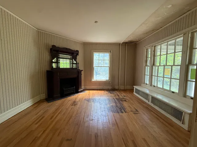a view of a livingroom with wooden floor and a fireplace