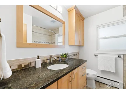 a bathroom with a granite countertop sink and a mirror