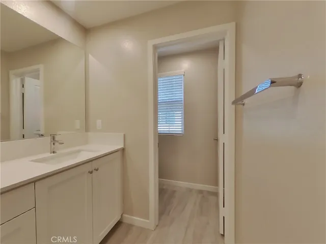 a en suite bathroom with a granite countertop sink and a mirror