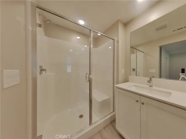 a bathroom with a shower sink vanity and mirror