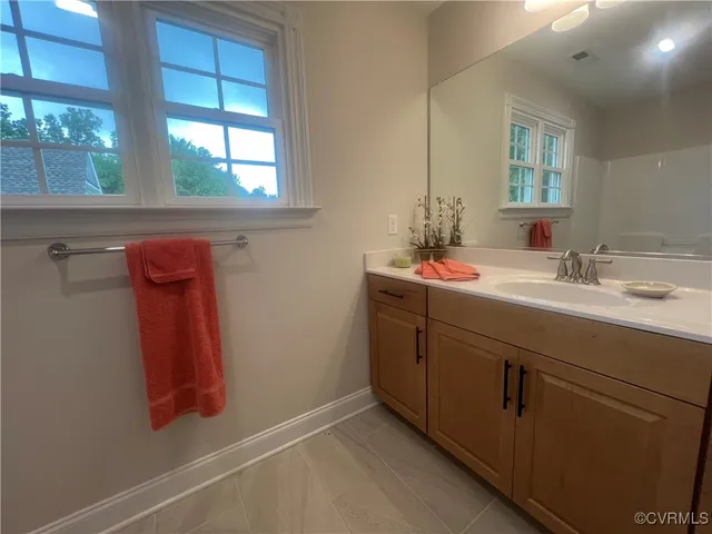 a bathroom with a sink vanity and mirror