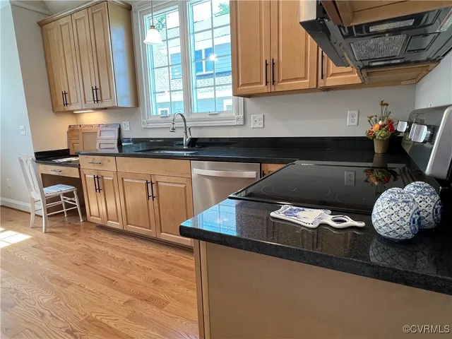 a kitchen with granite countertop a sink a stove and cabinets
