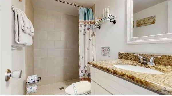 a bathroom with a granite countertop sink and a mirror