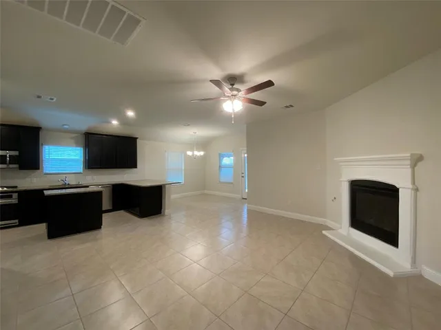 a view of a livingroom with a fireplace a sink and a kitchen counter top space