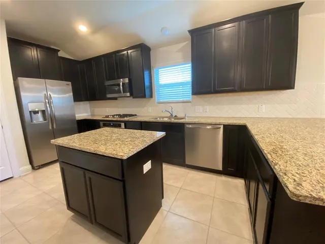 a kitchen with a stove sink and refrigerator