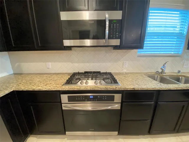 a stove top oven sitting inside of a kitchen