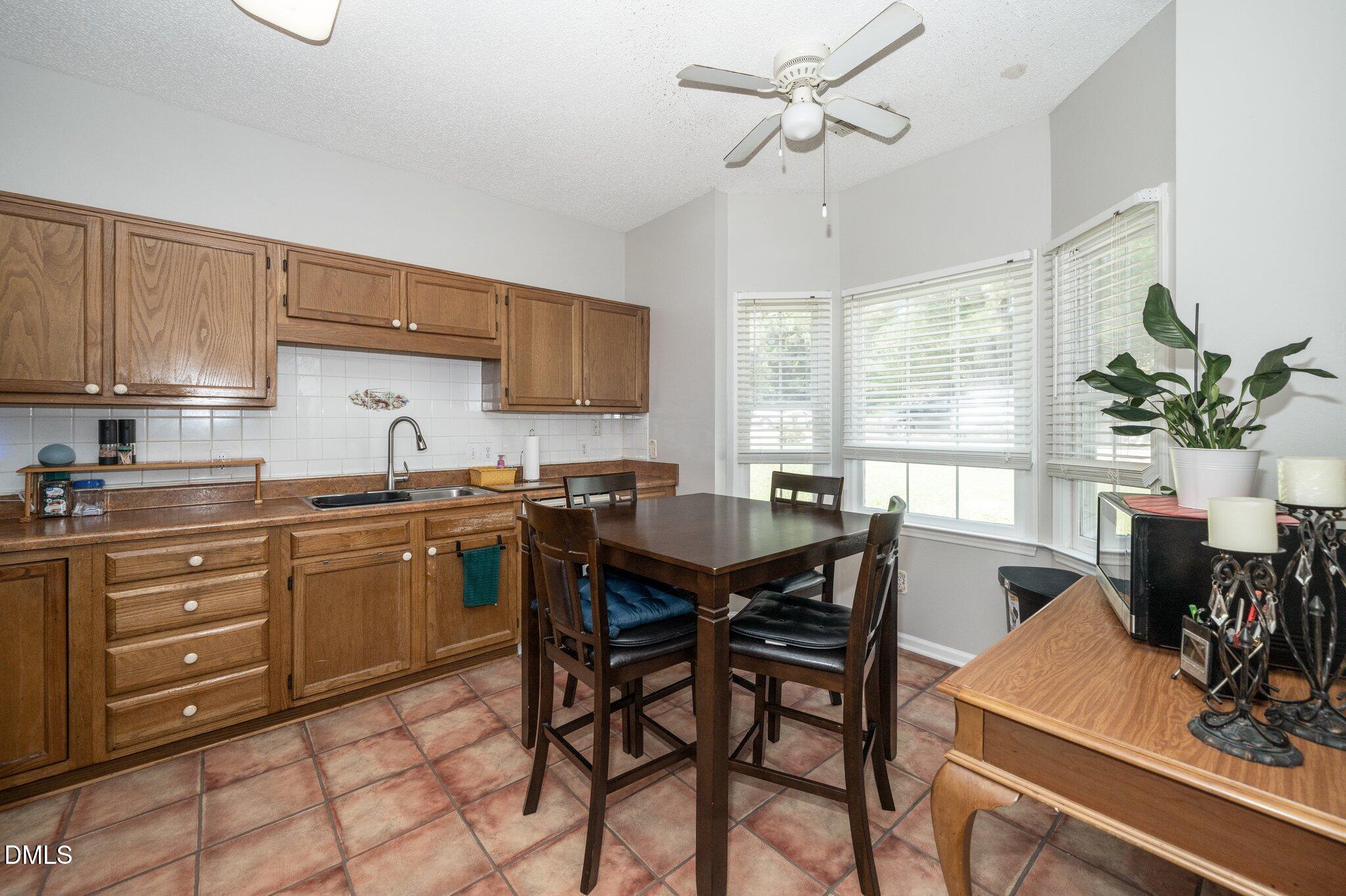 6008 River Lake Circle Raleigh, NC 27604 - Photo 3 of 16 a kitchen with a table chairs and white cabinets