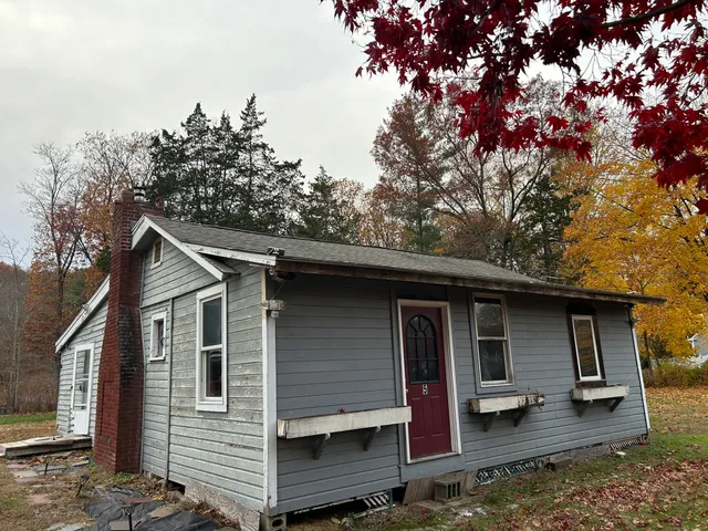 a view of a small house with a tree in the background