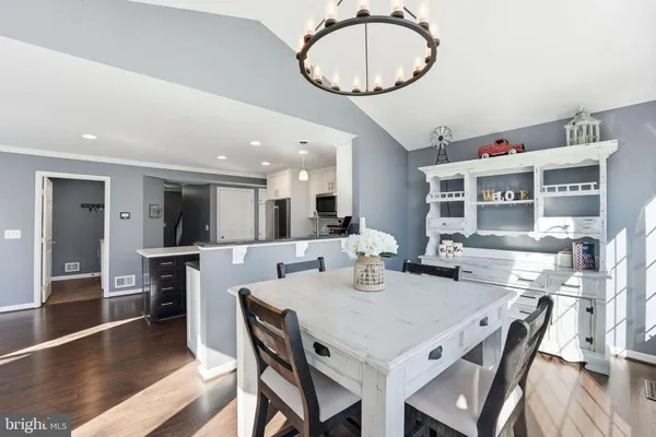 a living room with furniture a flat screen tv and kitchen view