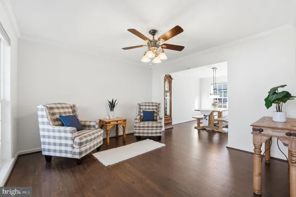 a living room with furniture wooden floor and a ceiling fan