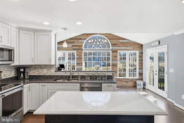 a view of a kitchen with granite countertop a sink and a window