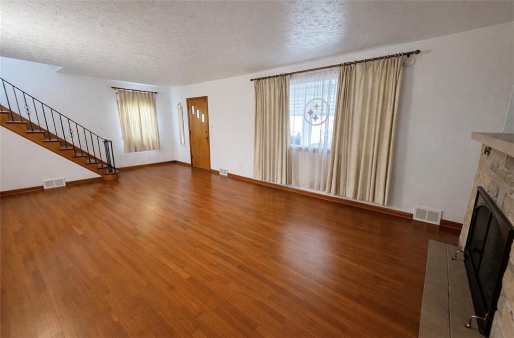 309 Emerson Street Vandergrift, PA 15690 - Photo 5 of 36 a view of an empty room with wooden floor and a window