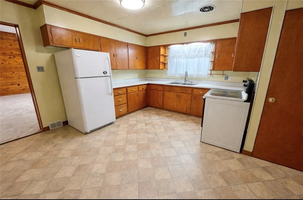 309 Emerson Street Vandergrift, PA 15690 - Photo 7 of 36 a kitchen with a refrigerator sink stove and cabinets