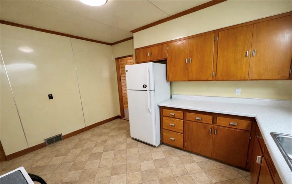 309 Emerson Street Vandergrift, PA 15690 - Photo 8 of 36 a kitchen with a refrigerator and cabinets