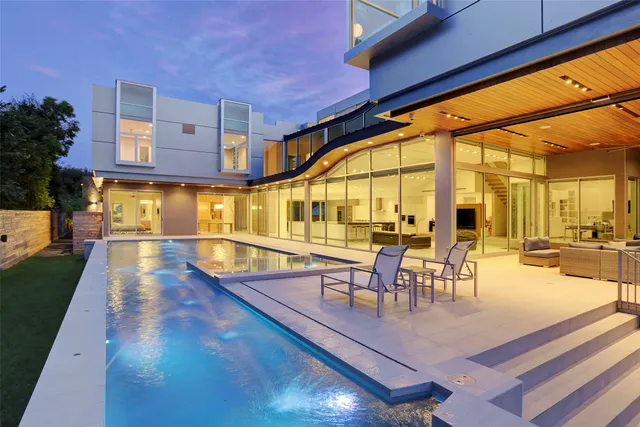 a dining room with wooden floor and large windows