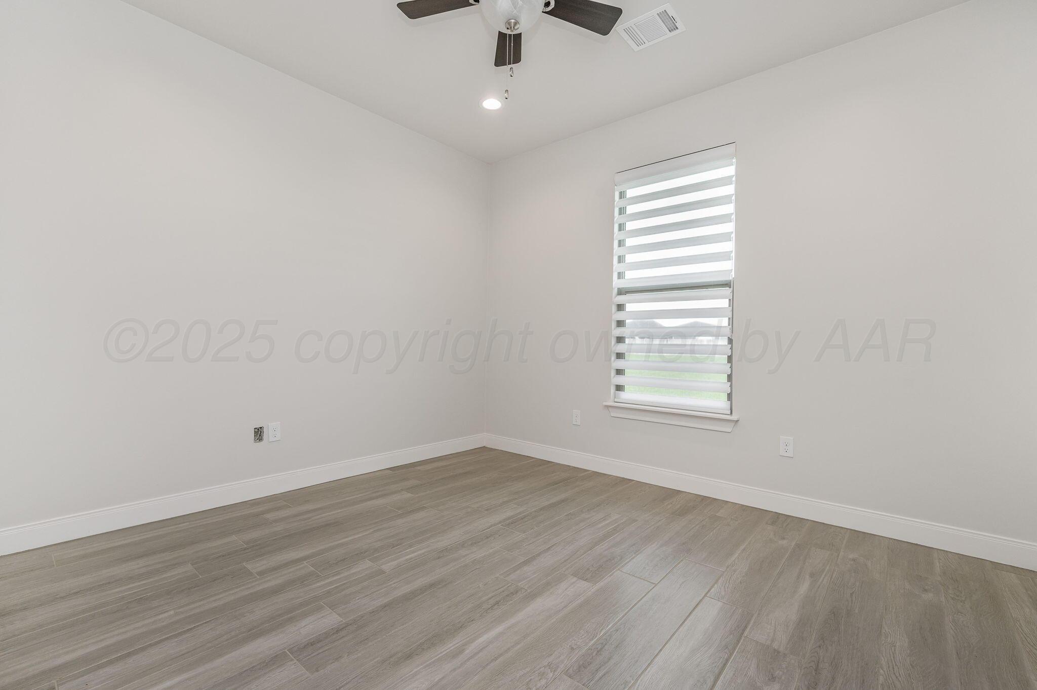 9734 Cicada Trail Amarillo, TX 79119 - Photo 19 of 34 wooden floor in an empty room with a window