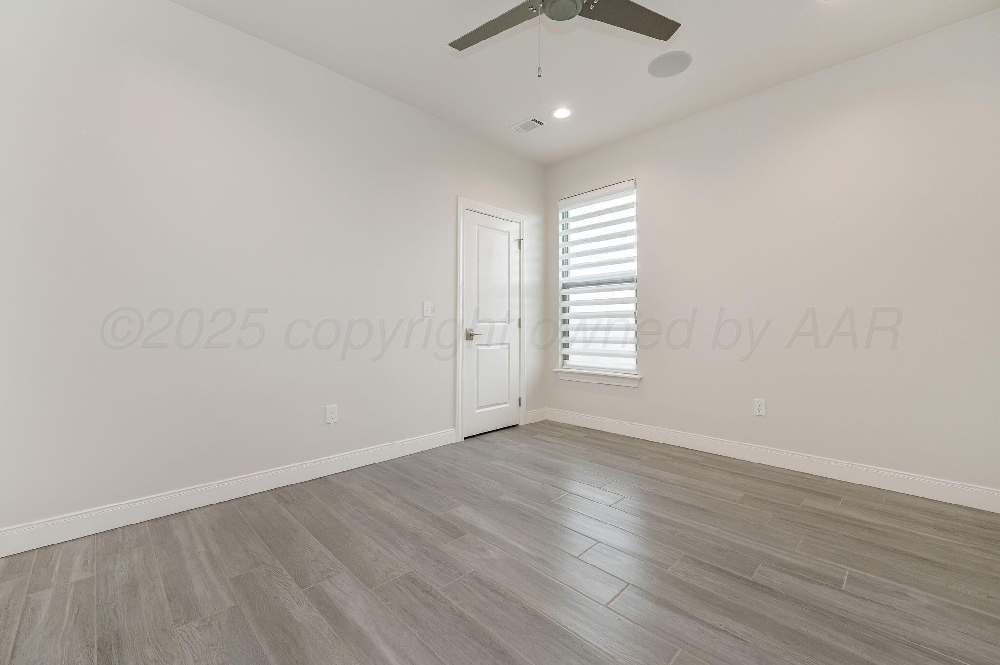 9734 Cicada Trail Amarillo, TX 79119 - Photo 20 of 34 an empty room with wooden floor and windows