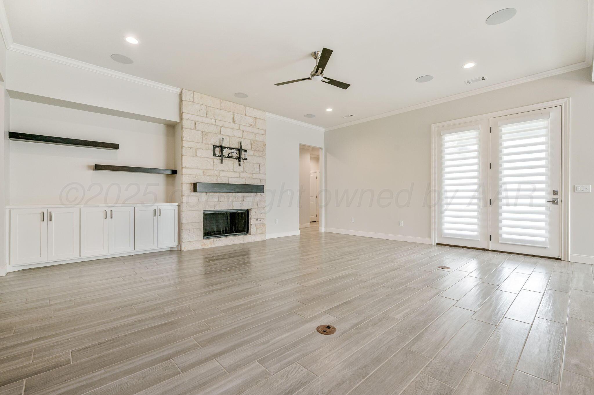 9734 Cicada Trail Amarillo, TX 79119 - Photo 8 of 34 a view of a livingroom with a fireplace a ceiling fan and wooden floor