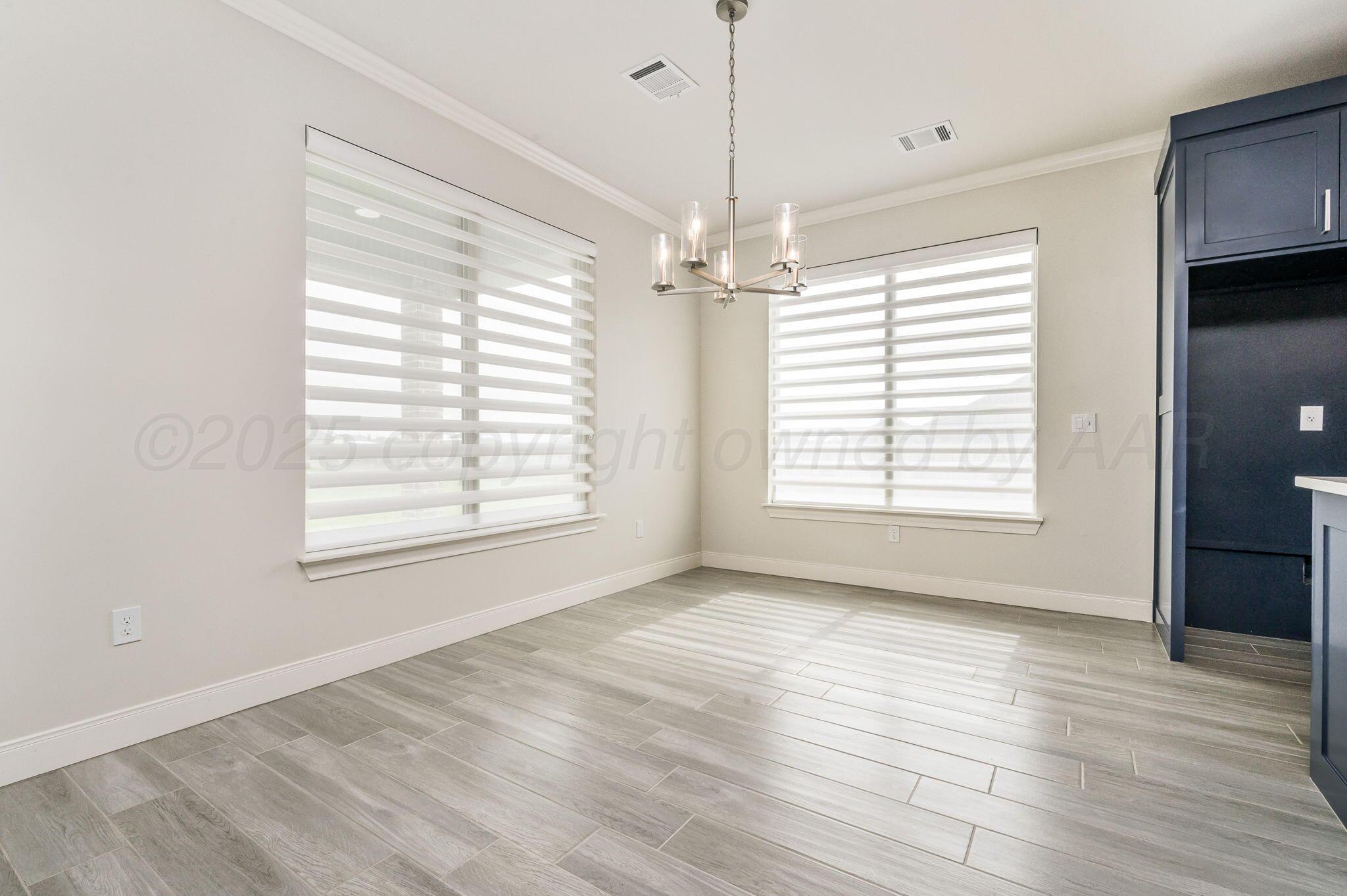 9734 Cicada Trail Amarillo, TX 79119 - Photo 9 of 34 a view of an empty room with wooden floor and a window