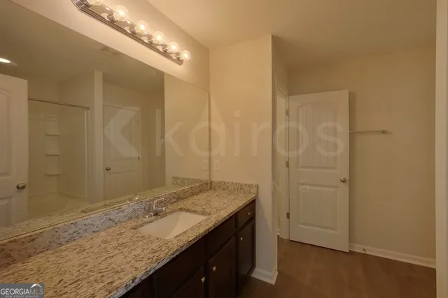 a bathroom with a granite countertop sink and a mirror