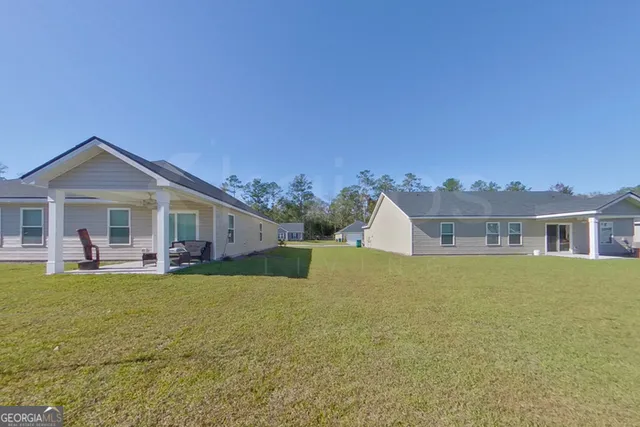 a front view of house with yard barbeque and outdoor seating