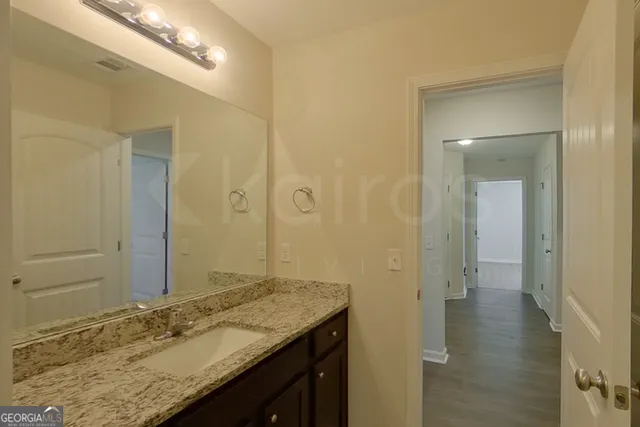 a bathroom with a granite countertop sink and a mirror