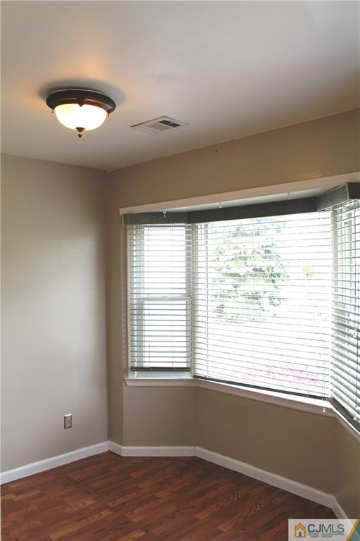 59 La Rue Lane, Unit 59 East Brunswick, NJ 08816 - Photo 2 of 17 a view of an empty room with wooden floor and a window