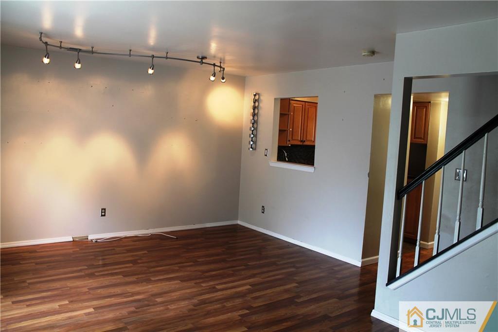 59 La Rue Lane, Unit 59 East Brunswick, NJ 08816 - Photo 11 of 17 a view of an empty room with wooden floor and stairs