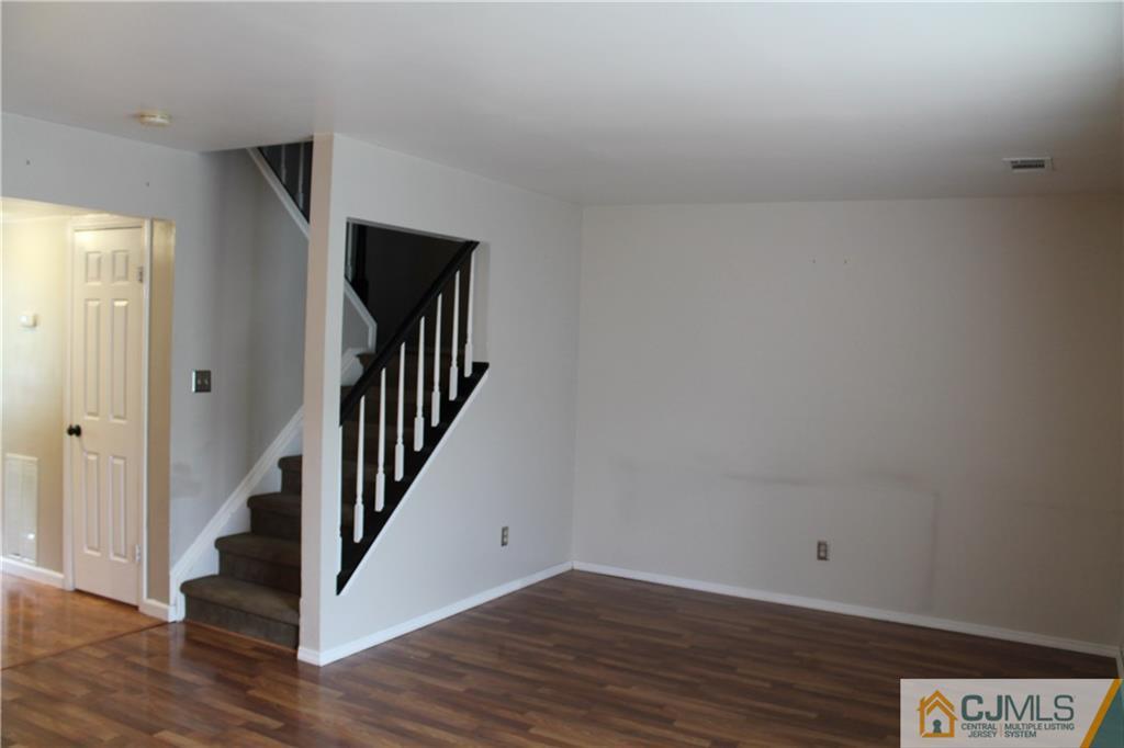 59 La Rue Lane, Unit 59 East Brunswick, NJ 08816 - Photo 13 of 17 a view of a hallway with wooden floor and staircase