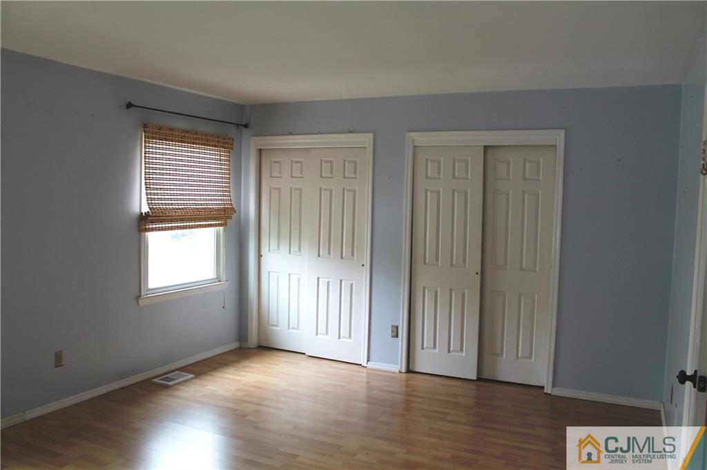 59 La Rue Lane, Unit 59 East Brunswick, NJ 08816 - Photo 14 of 17 an empty room with wooden floor and windows