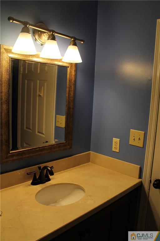 59 La Rue Lane, Unit 59 East Brunswick, NJ 08816 - Photo 16 of 17 a bathroom with a sink and mirror