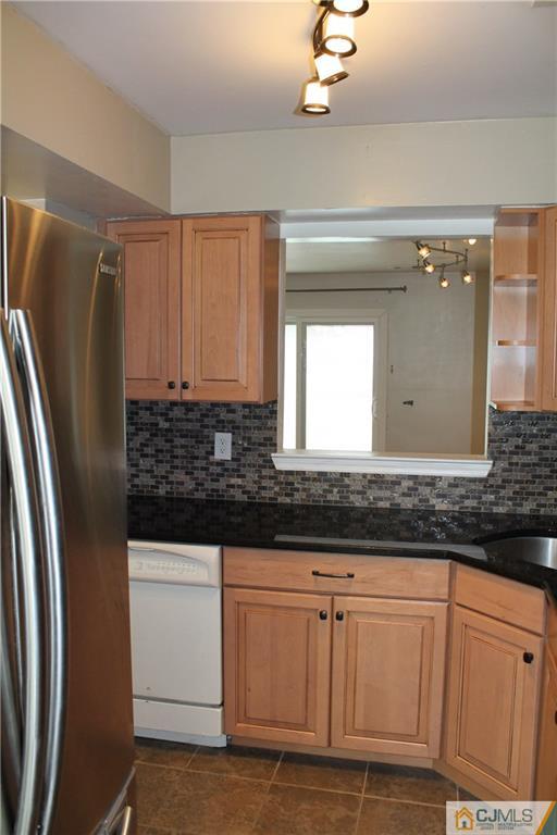 59 La Rue Lane, Unit 59 East Brunswick, NJ 08816 - Photo 9 of 17 a kitchen with granite countertop a refrigerator and a sink