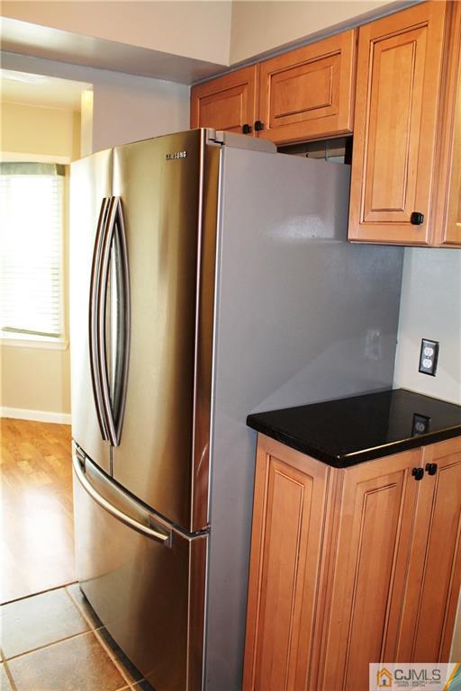 59 La Rue Lane, Unit 59 East Brunswick, NJ 08816 - Photo 10 of 17 a close view of a refrigerator a cabinet and a black granite counter top