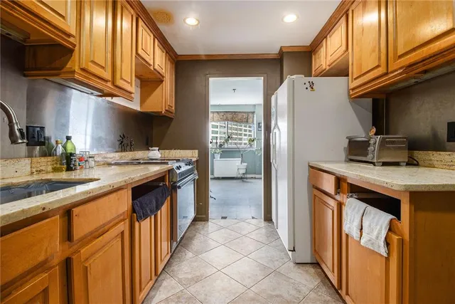 a kitchen with stainless steel appliances granite countertop a sink a stove and a refrigerator