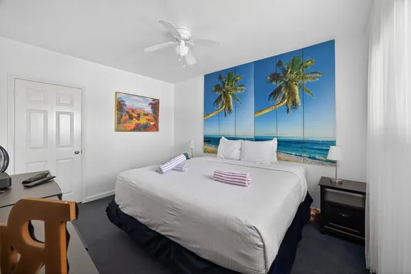 a bedroom with a bed and a painting on the wall