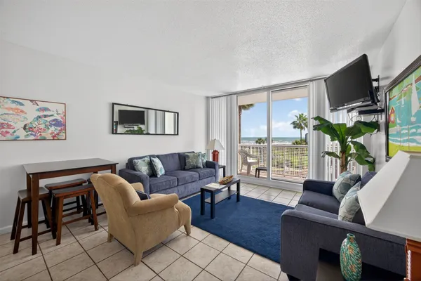 a living room with furniture a flat screen tv and a large window