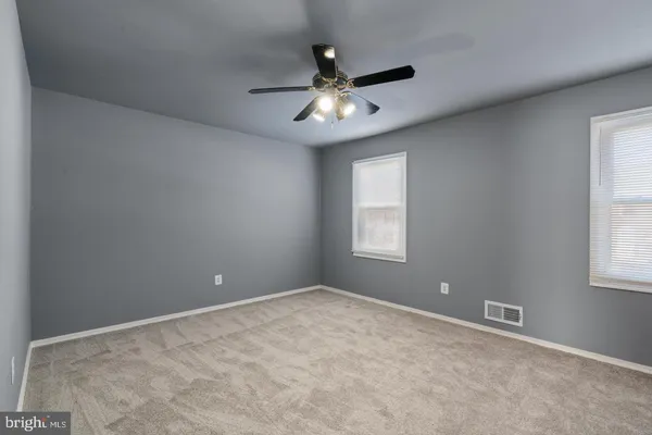 an empty room and window and a ceiling fan