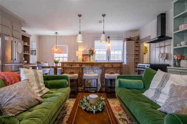 a living room with furniture and a view of kitchen