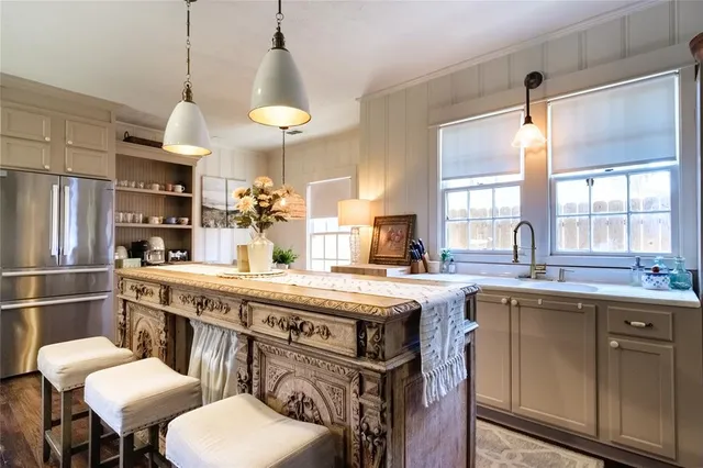 a kitchen with stainless steel appliances granite countertop a sink a stove and a refrigerator