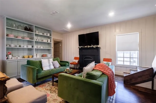a living room with furniture a flat screen tv and a fireplace