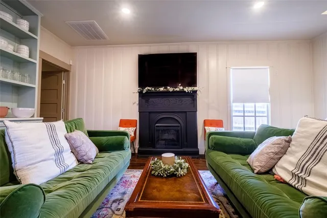 a living room with furniture a flat screen tv and a fireplace