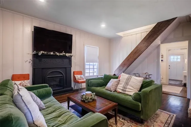 a living room with furniture a flat screen tv and a fireplace